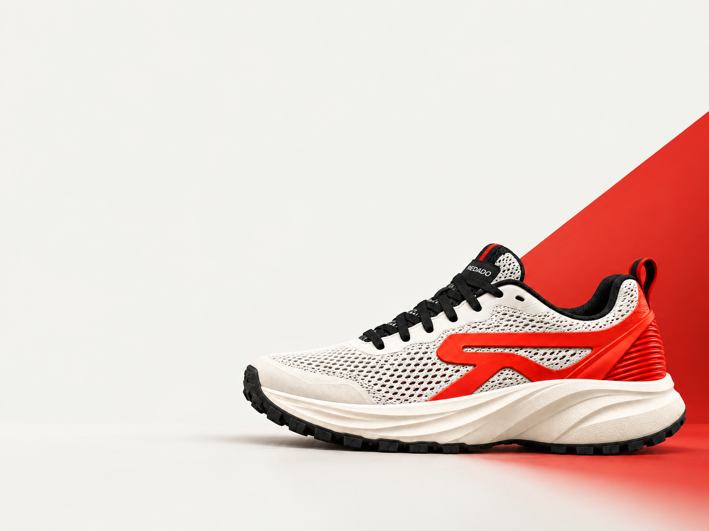 Illustrative white and red Redado shoe with a red campaign accent.
